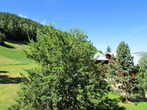 Une maison entourée d’une végétation luxuriante, sous un ciel bleu azur.