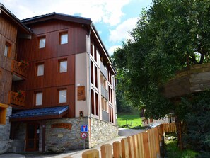 A multi-story building with a stone facade and wooden balconies. - Cozy apartment for 5 in Montchavin, near the slopes (Bellentre)