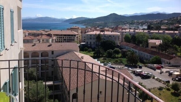 A coastal town with buildings, a clear sky, and mountains in the background. - T2 Very quiet, close to beaches and town center, sea and mountain views (L'île-Rousse)