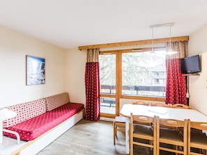 Enjoy a compact room with a bench, dining table, and flat-screen TV.