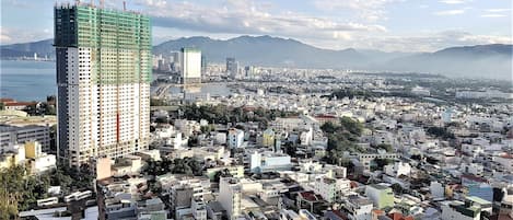 Stunning city views from a high-rise building under construction, overlooking a body of water and distant mountains.