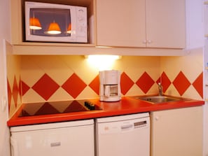 A kitchen with a microwave, coffee maker, and a sink.