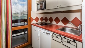 Eine kleine Küche mit Geschirrspüler, Spüle und Mikrowelle.