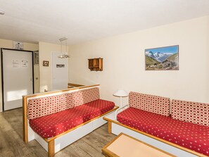Cozy retreat with a kitchenette, seating areas, and a door leading to another space.