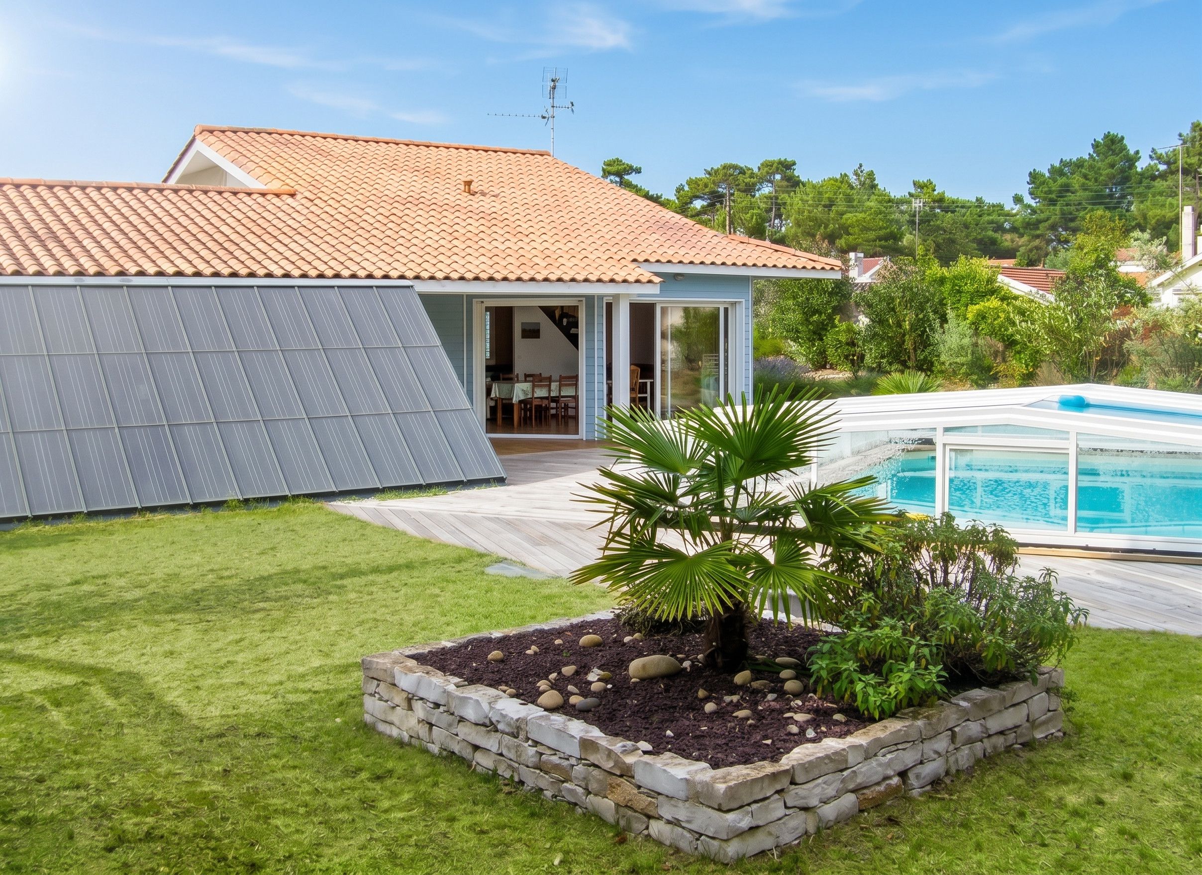 Une maison avec un toit en tuiles, une piscine et un jardin agrémenté d’un palmier.