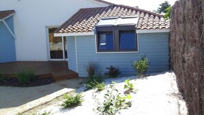 A single-story house with a tiled roof, a front door, and a small porch. - Homerez - Villa in Saint Hilaire de Riez (Saint Hilaire de Riez)