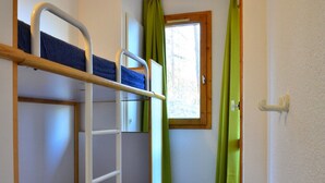 Camera con letto a castello, finestra e tende.