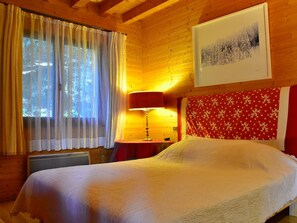 Cozy bedroom with a bed, bedside table, and framed picture.