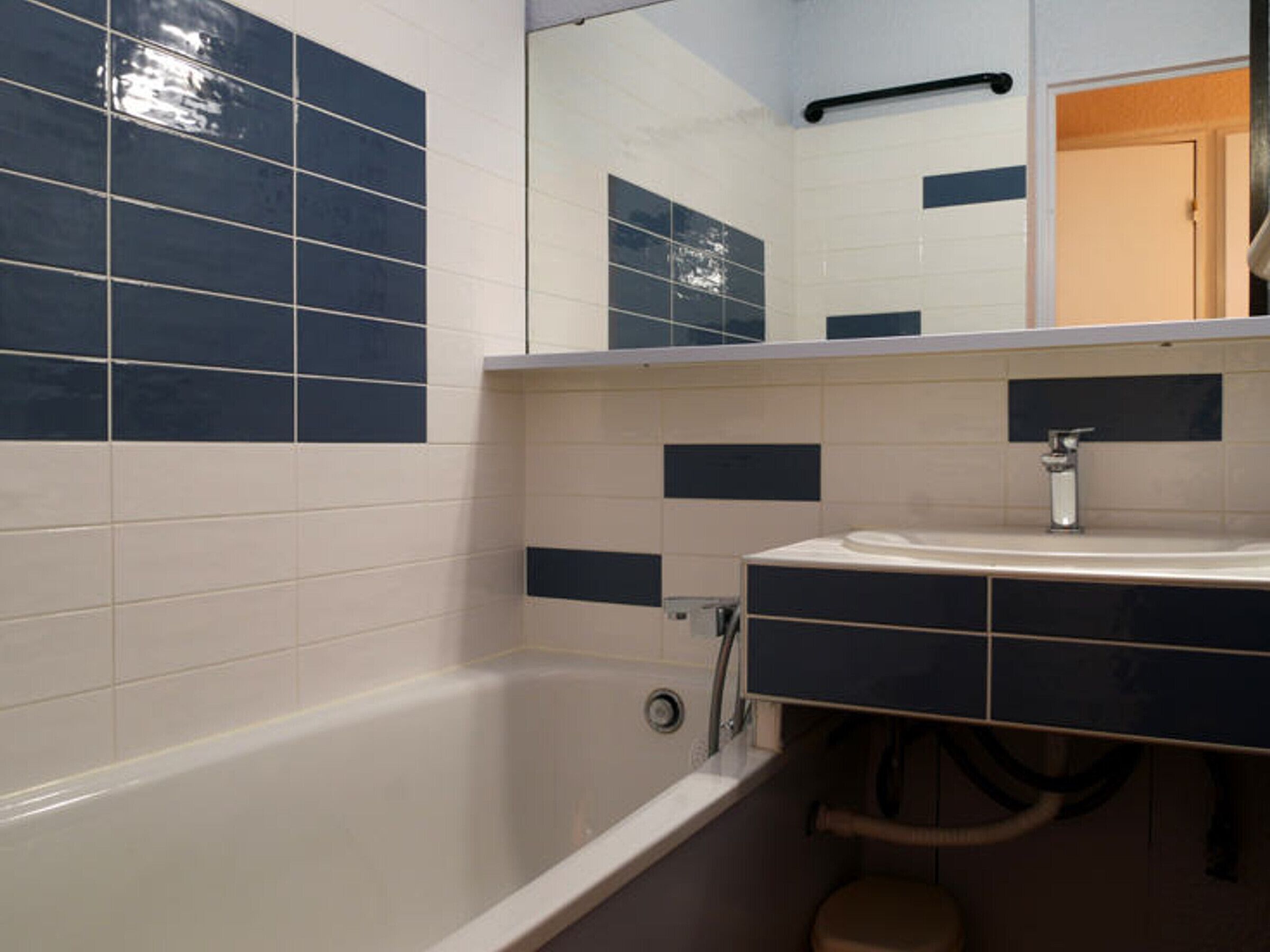 Une salle de bain avec une baignoire, un lavabo et un miroir.