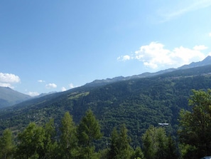 A mountainous landscape with dense forest and a clear sky.