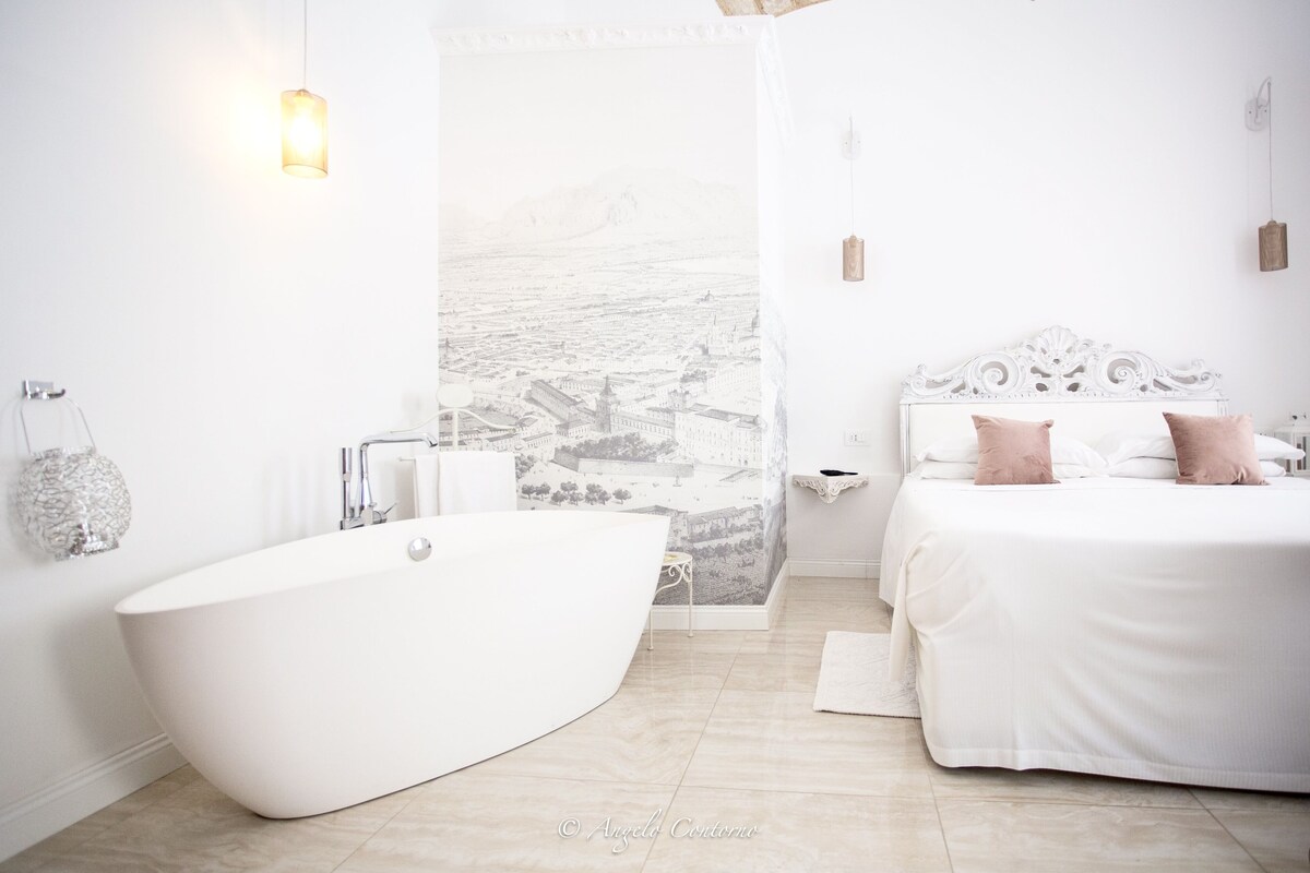 A modern bathroom with a freestanding bathtub, a large mirror, and a wall-mounted sink.