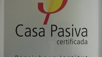 A sign with the logo and name 'Casa Pasiva certificada' and 'Passivhaus Institut' indicating a certified Passivhaus building.