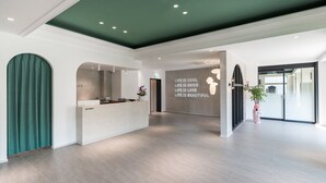 A modern reception area with a green ceiling, a reception desk, and a wall with inspirational quotes.