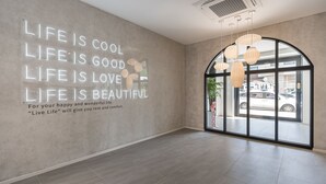 A spacious room with a large window, a wall with motivational text, and a modern pendant light.