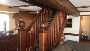 A wooden staircase with a handrail and carpeted steps leading to an upper floor.