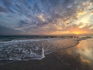 A beach with waves and a sunset. - RELAX & WATCH THE DOLPHINS ON THE INTERCOASTAL OR TAKE A 5 MIN WALK TO THE BEACH (Treasure Island)