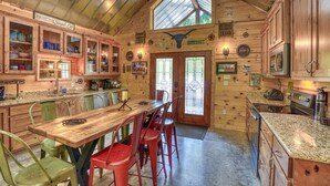 Una cocina rústica con armarios de madera, una mesa de comedor de madera y una zona de bar.