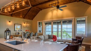A spacious kitchen with a large island, a dining area with a view, and a cozy seating area with a fireplace.