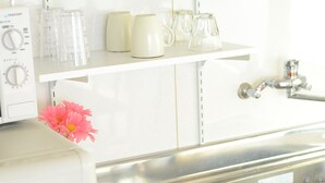 Una cocina con encimera blanca, un fregadero y un calentador de agua.