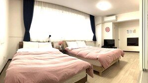 Una habitación de hotel con dos camas, un televisor y un reloj en la pared.