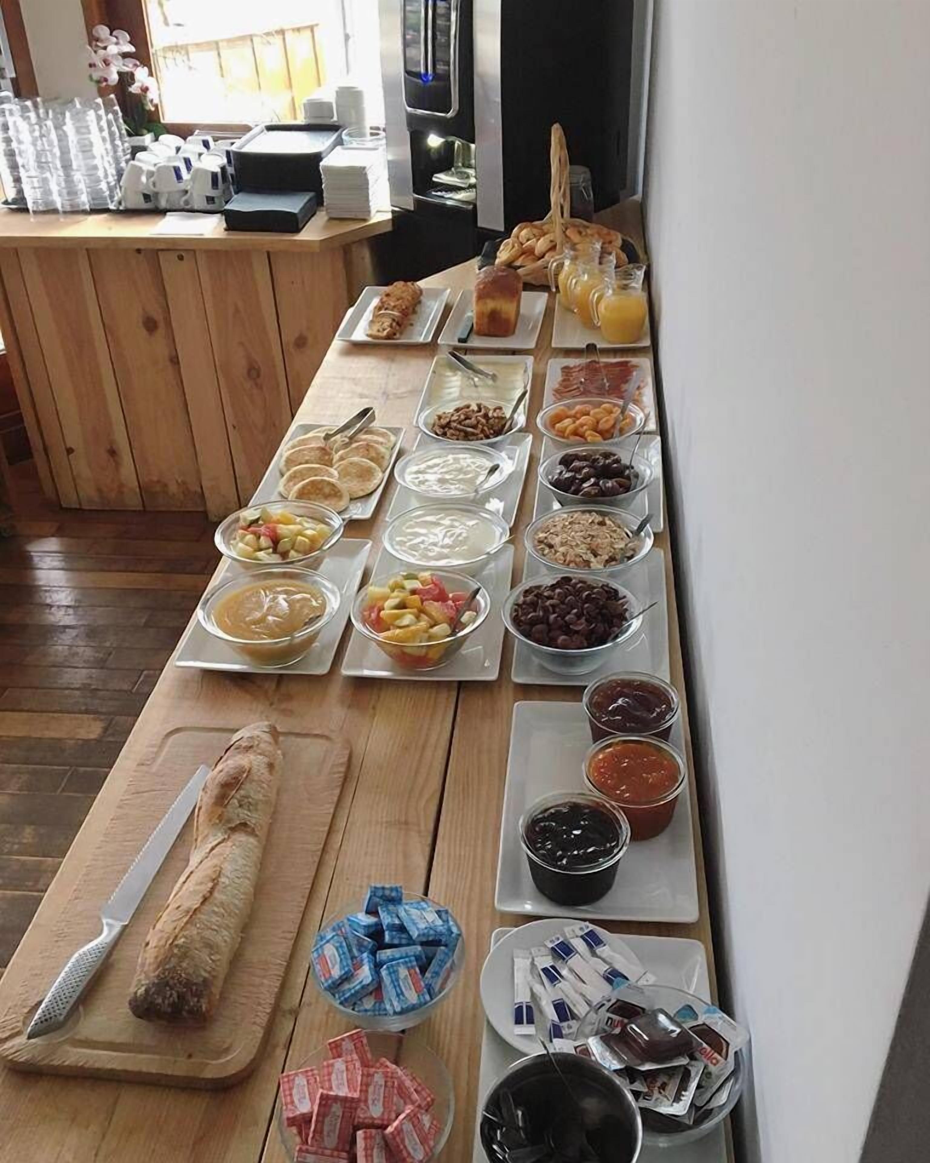 A buffet table with various food items and condiments.