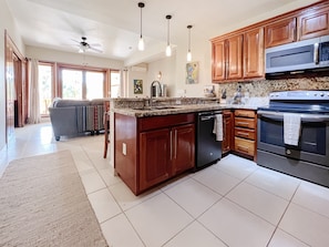 A kitchen with wooden cabinets, a dishwasher, a microwave, and an oven.