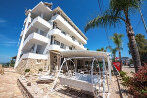 A multi-story hotel with balconies, outdoor seating, and a covered patio area. - Hotel Murati (Ksamil)