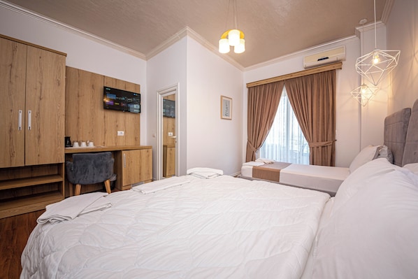 A modern hotel room with a large bed, a desk, a chair, and a TV mounted on the wall. - Hotel Murati (Ksamil)