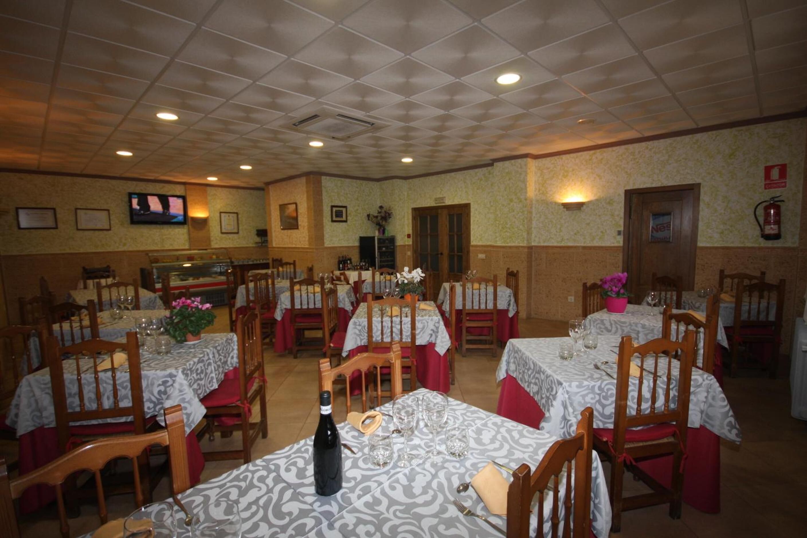 Un restaurante con varias mesas y sillas, cada una con manteles estampados.
