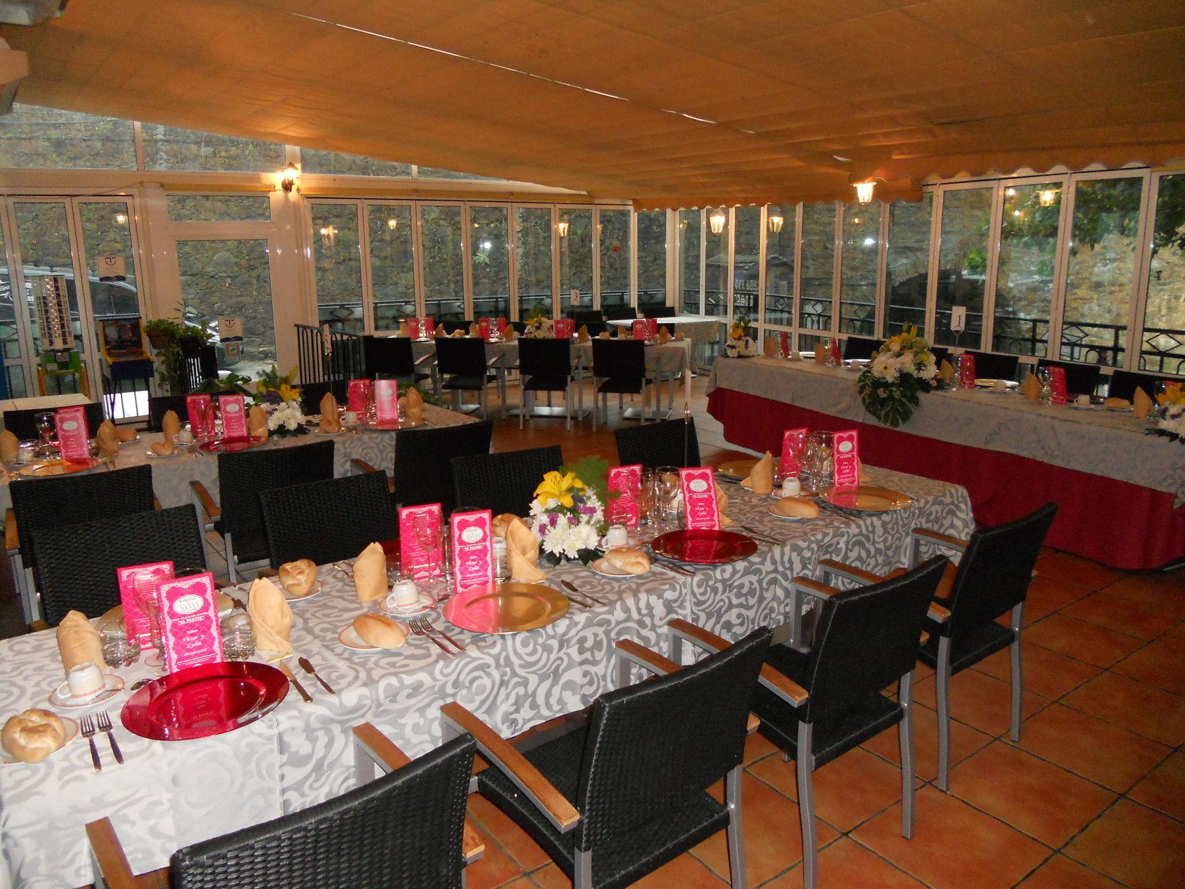 A restaurant with round tables set for dining, featuring menus and table settings.