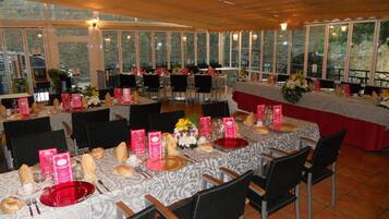 A restaurant with round tables set for dining, featuring menus and table settings.