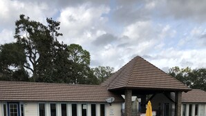 A swimming pool with a tiled deck, lounge chairs, and a covered seating area. -  Thomas' Store- Remodeled in Oct 2021, pet friendly (Steinhatchee)