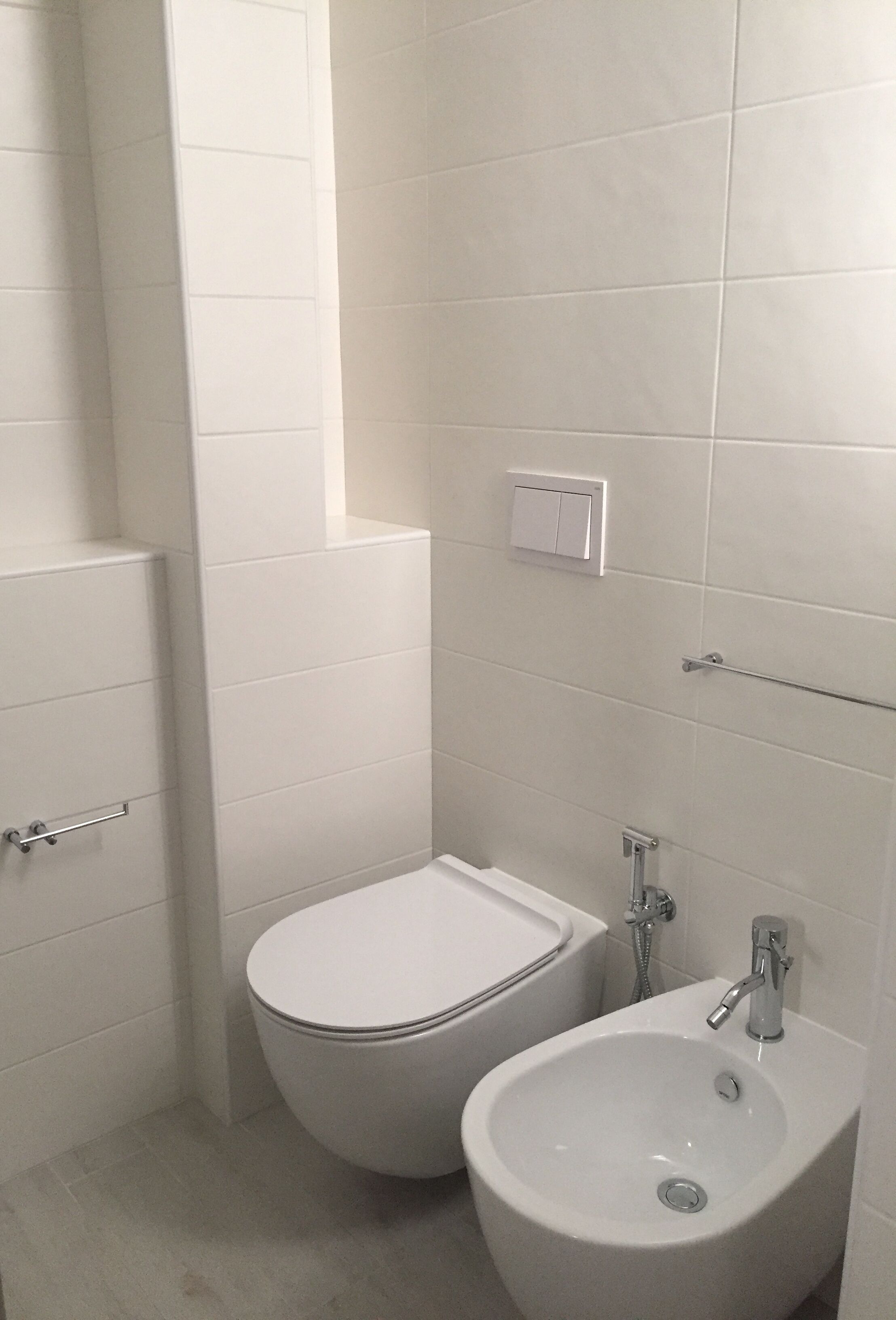 Une salle de bain équipée de toilettes, d’un bidet et d’un lavabo.