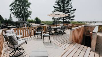 Enjoy a serene view of the water from this outdoor deck, complete with comfortable seating and a shaded area.