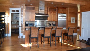 L’intérieur est en bois et comprend un coin cuisine équipé d’une cuisinière, d’un four et d’un réfrigérateur. On y trouve également quatre tabourets de bar et une porte qui donne sur une autre pièce.
