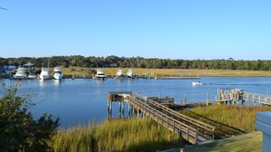 Un port de plaisance avec des bateaux amarrés, des quais en bois et une rive herbeuse.