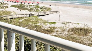 Een strand met een houten looppad en parasols.