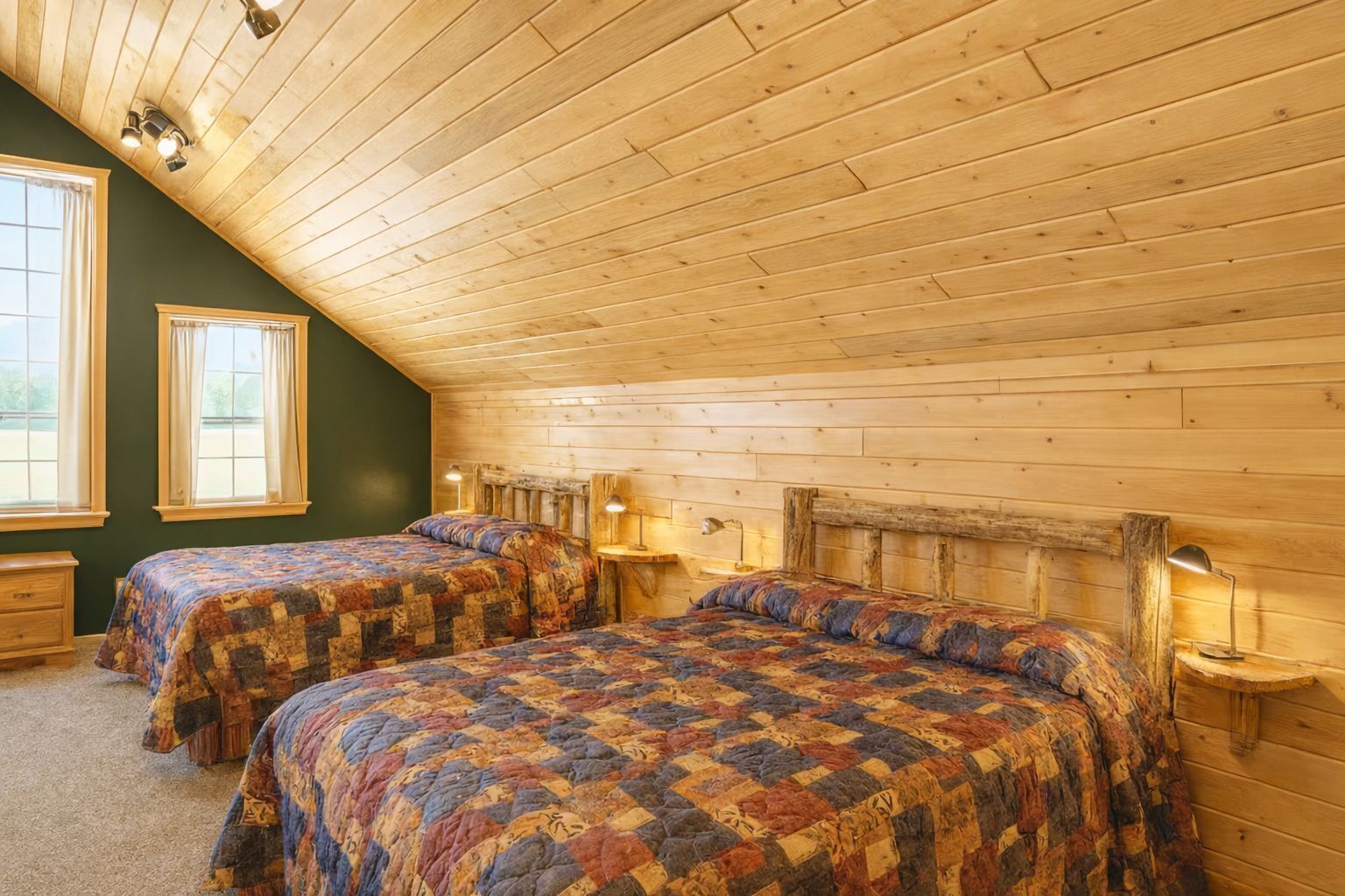 Une chambre mansardée chaleureuse, avec deux lits, des murs en bois et un plafond en pente.