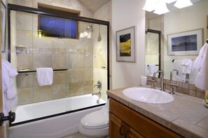 Une salle de bain équipée d’une baignoire, de toilettes, d’un lavabo et d’une douche.