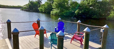 A wooden dock with chairs and a rope barrier.