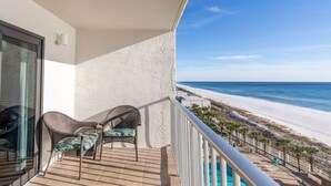 A balcony with wicker chairs and a view of the beach. - The Summit 1BR 1.5BA Beautiful unit with great views! (Panama City Beach)