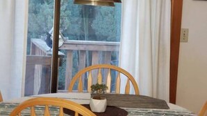 A dining area with a table, chairs, and a potted plant. - Beautiful Home with Traditional & Modern Ambience (Edmonds)