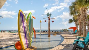 Zona de piscina con sillas de descanso y una palmera.