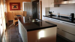Una cocina moderna con una isla central, electrodomésticos de acero inoxidable y un salpicadero de azulejos.