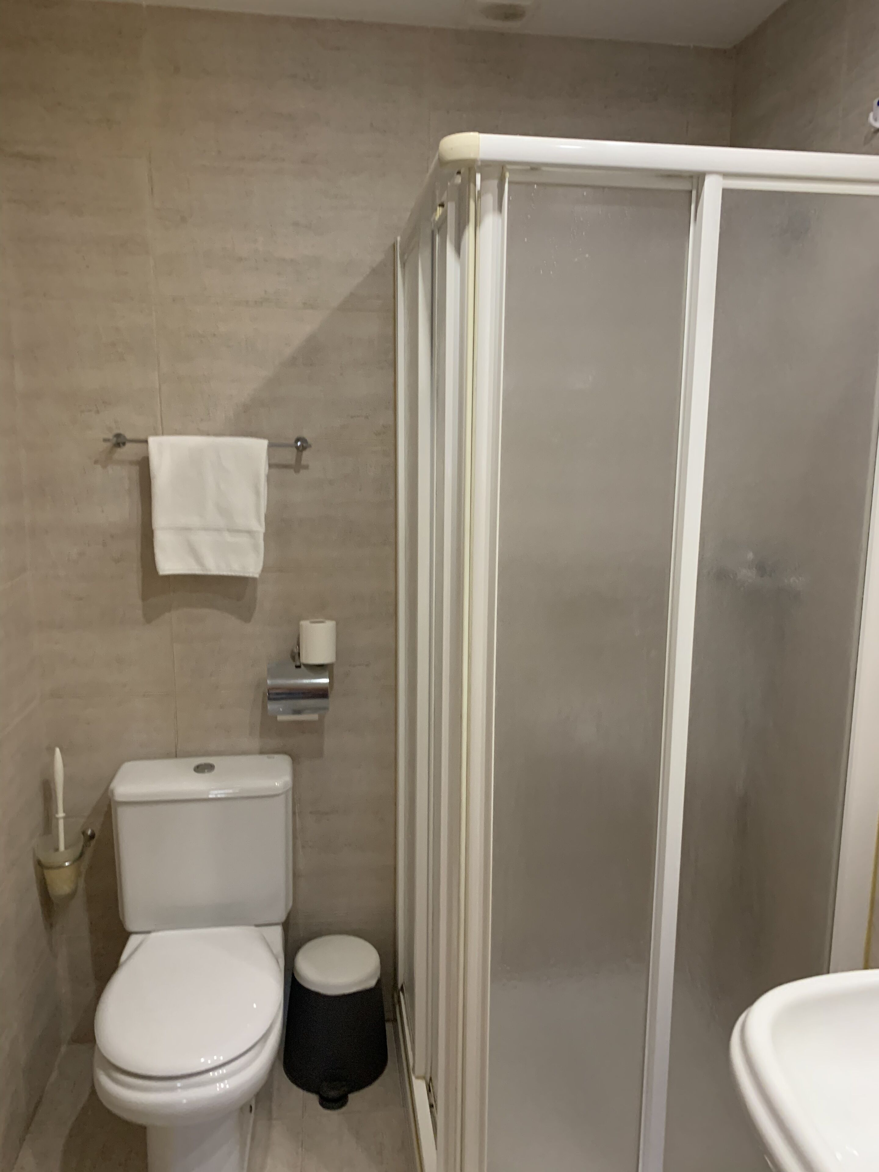 Un bany amb vàter, plat de dutxa i rentapans.