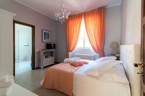 A bedroom with a bed, a dresser, a television, and a window with curtains. - B&B 3 Tigli (Maslianico)