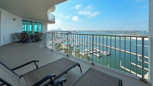 Un balcón con vista a un puerto deportivo y al horizonte de la ciudad.