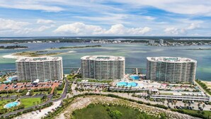 Un resort con tres edificios de gran altura, una piscina central y un puerto deportivo.