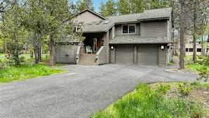 A two-story house with a front entrance, a covered porch, and a garage. - NEW Mountain Home at the Deschutes River,Bikes,Game Room,Hot Tub,AC,SHARC Passes (Bend)