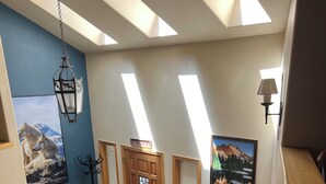 A staircase with wooden steps leading to a landing with a door marked "Bless the House." - NEW Mountain Home at the Deschutes River,Bikes,Game Room,Hot Tub,AC,SHARC Passes (Bend)